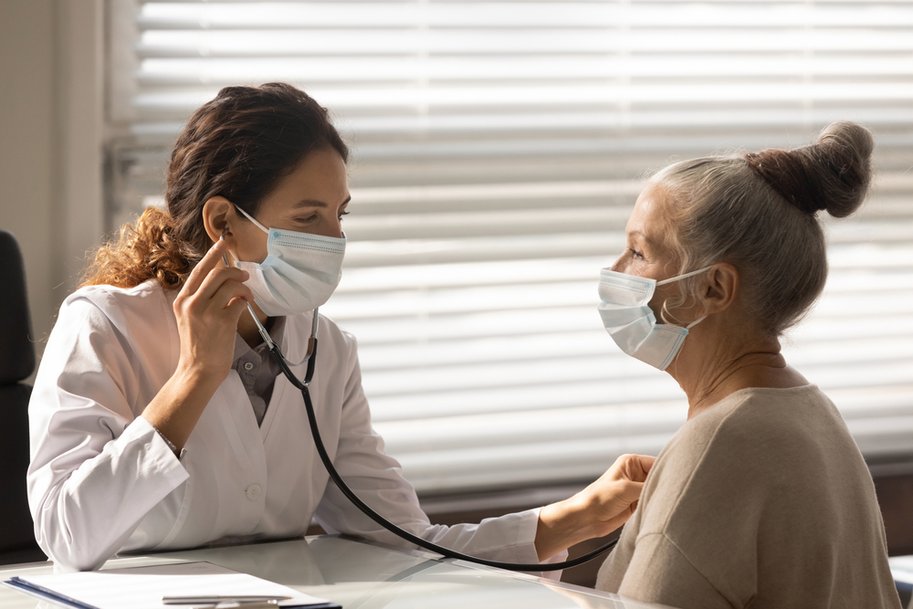 Healthcare professional examining an elderly patient with a stethoscope