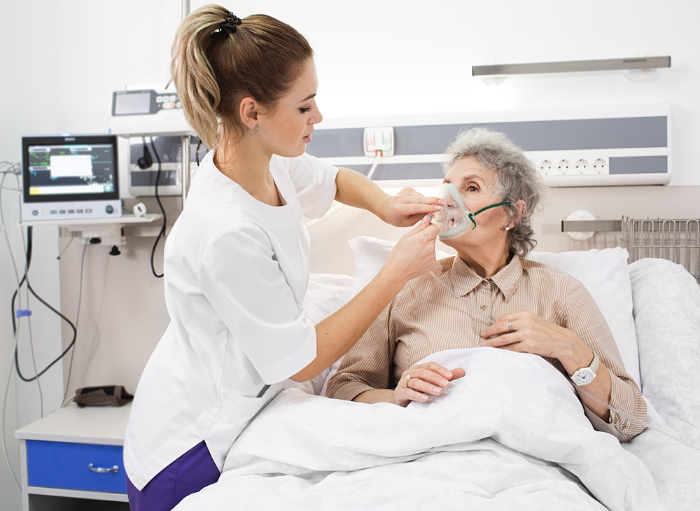 Respiratory therapist assisting patient with oxygen mask