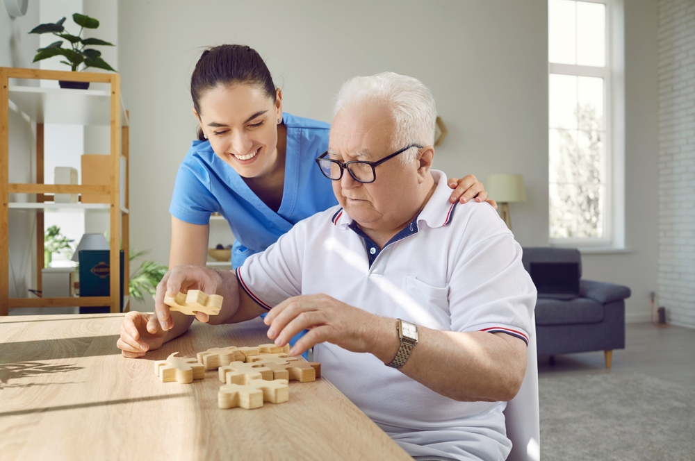 Caregiver assisting elderly resident with puzzle activity
